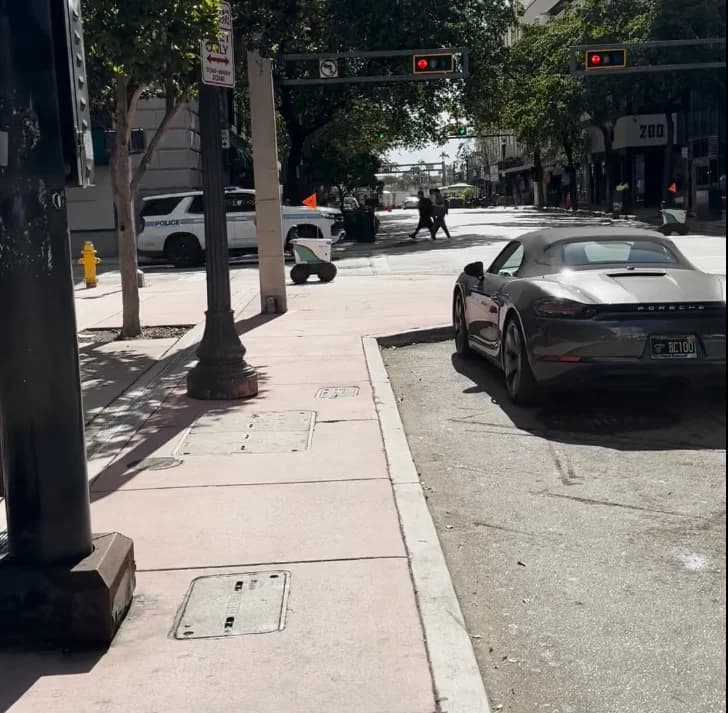 Downtown Miami street with a sports car and delivery robot